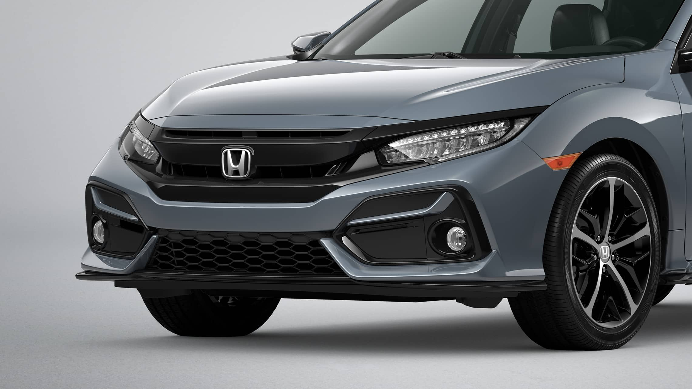 Primer plano frontal del lado del conductor del Honda Civic Sport Touring Hatchback 2021 en Sonic Gray Pearl.