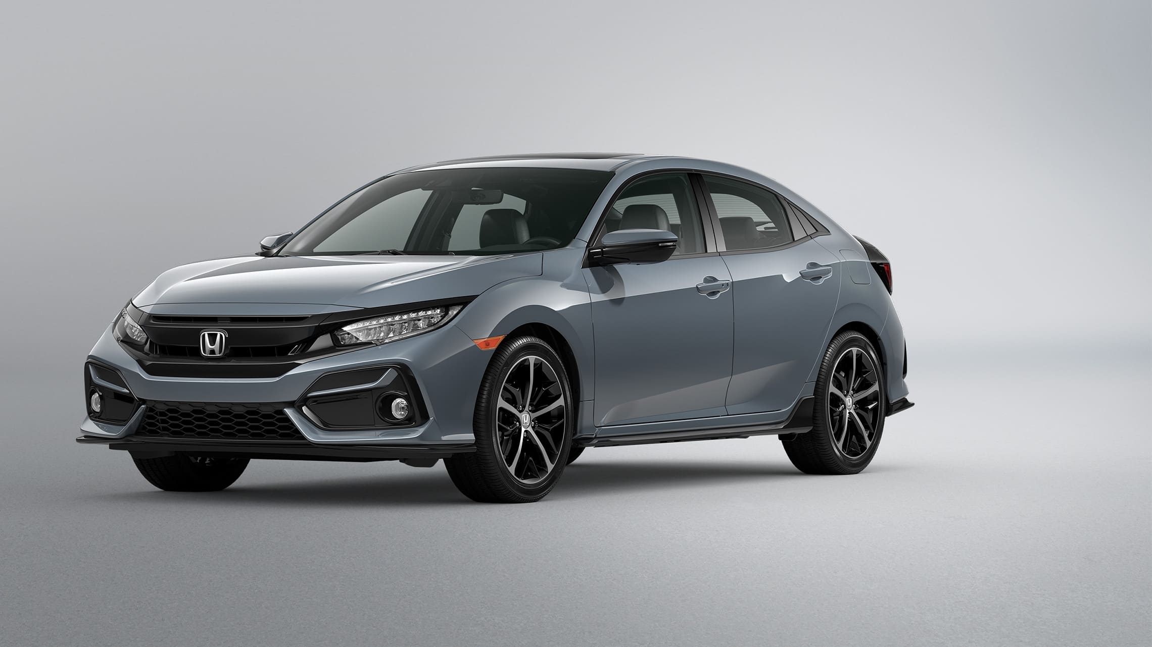 Vista frontal desde el lado del conductor del Honda Civic Sport Touring Hatchback 2021 en Sonic Gray Pearl.